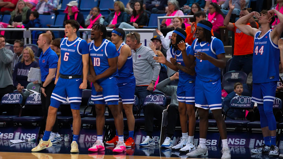 A group of men staring in the same direction on the basketball court.