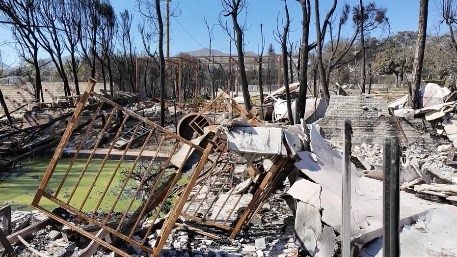 Pieces of rubble and a green pool from the wildfires