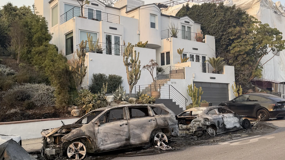 Burnt down cars in front of a home