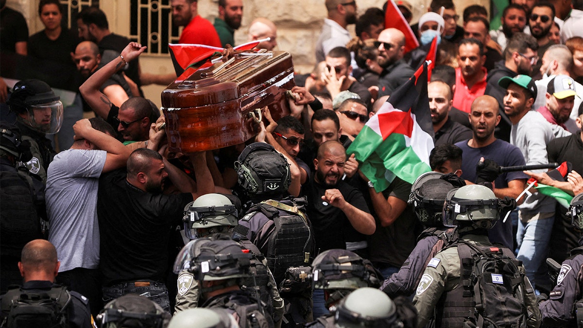 Family and friends carry the coffin of Al Jazeera reporter Shireen Abu Akleh, who was killed during an Israeli raid in Jenin in the occupied West Bank, as clashes erupted with Israeli security forces, during her funeral in Jerusalem, May 13, 2022. REUTERS/Ammar Awad